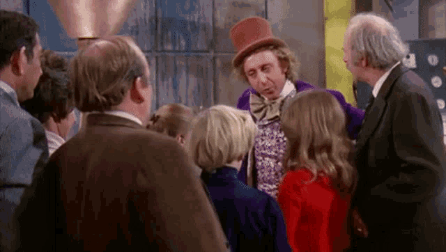 a group of people are standing around a man wearing a top hat and bow tie .