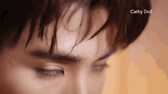 a close up of a man 's face with his eyes closed and his hair blowing in the wind .