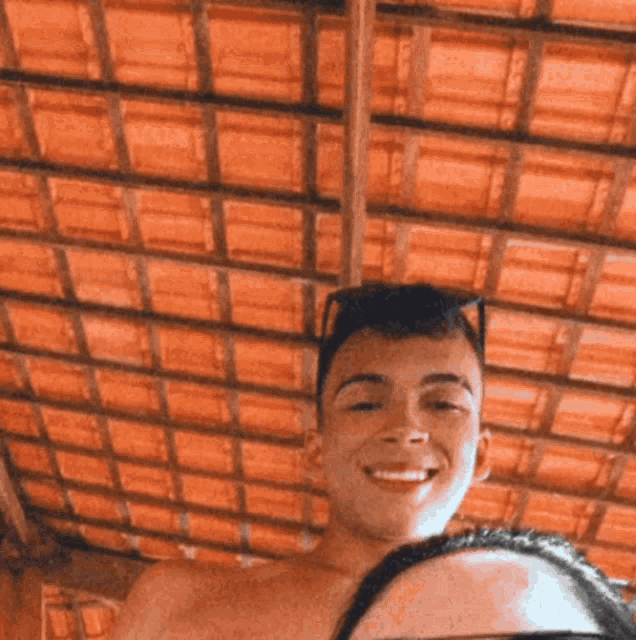 a man and woman are posing for a picture in front of a tiled roof