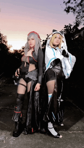 two women in costumes pose for a picture together