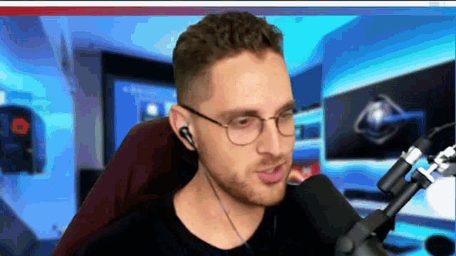 a man wearing glasses and headphones is talking into a microphone