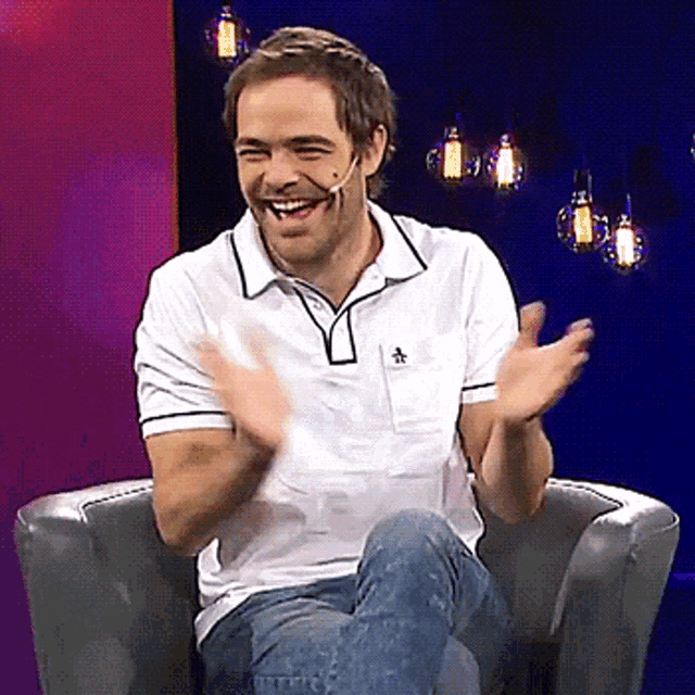 a man wearing a white polo shirt with a penguin on the pocket