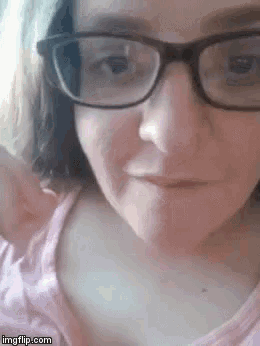 a close up of a woman wearing glasses and a pink tank top .