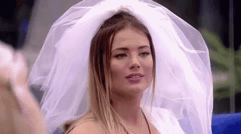 a woman in a wedding dress and veil is sitting on a chair .