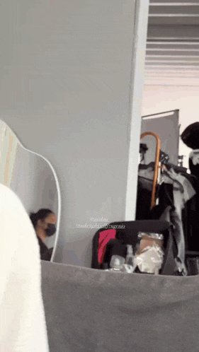 a woman wearing a mask is looking at herself in a mirror .