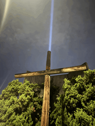 a wooden cross with a light coming out of the top of it