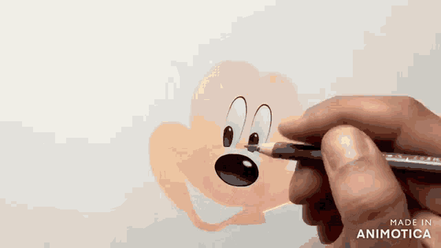 a person is drawing a cartoon character with a pencil on a piece of paper .