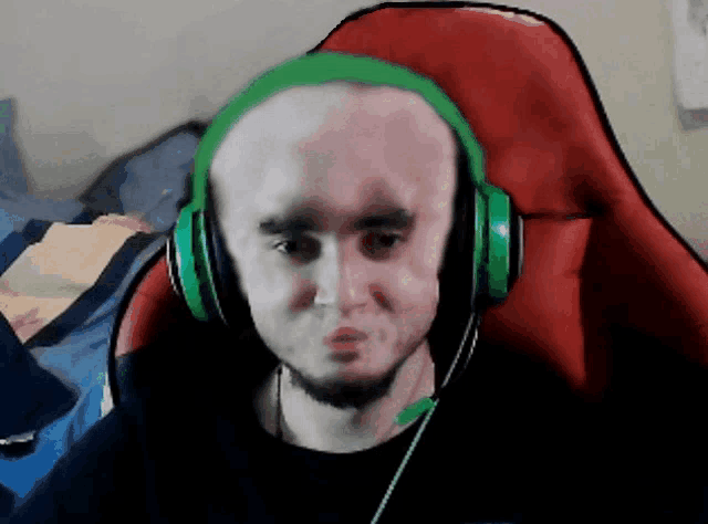 a bald man wearing green headphones is sitting in a chair