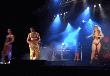 three people are dancing on a stage with blue lights