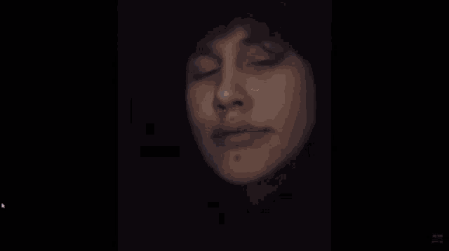a close up of a woman 's face with her eyes closed and a nose ring