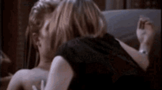 a man and a woman are kissing on a couch in a room .
