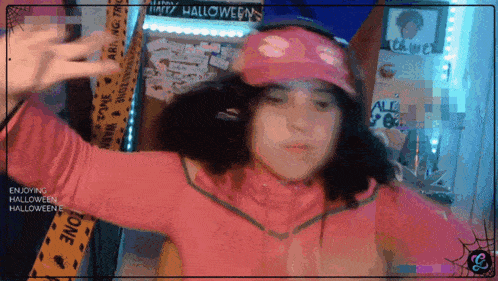a girl wearing a pink jacket and a pink hat with the words enjoying halloween on the bottom