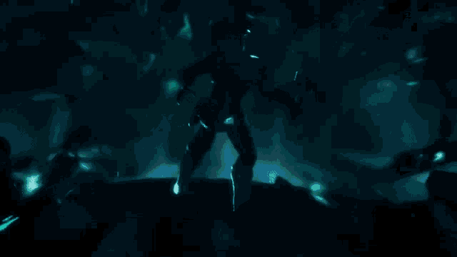 a person is holding a green object in their hand in a dark room .
