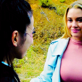 two women are standing next to each other and smiling at each other