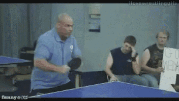 a man is playing ping pong with a sign that says go media