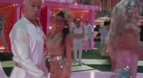 a man and a woman are dancing on a pink and white dance floor .