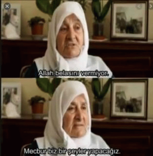 an elderly woman wearing a hijab is sitting in front of a table and talking .