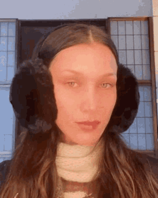 a woman wearing ear muffs and a scarf .