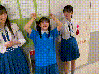 a group of girls are standing next to each other in a hallway .