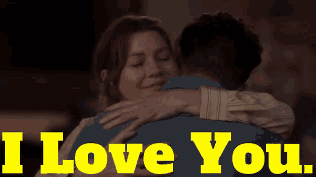 a woman hugging a man with the words " i love you " in yellow letters