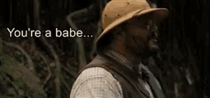 a man in a cowboy hat is standing in the woods and says you 're a babe .