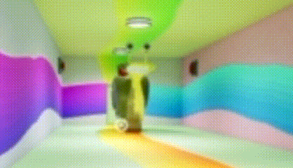 a blurry picture of a hallway with colorful walls and a person standing in the middle of it .