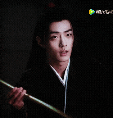 a man holding a stick with chinese characters on the bottom right
