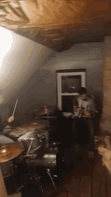 a man plays drums in a dark room