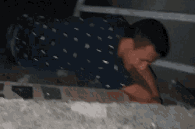 a man in a polka dot shirt is crawling on a wall