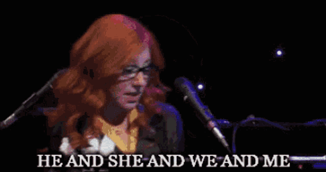 a woman singing into a microphone with the words he and she and we and me