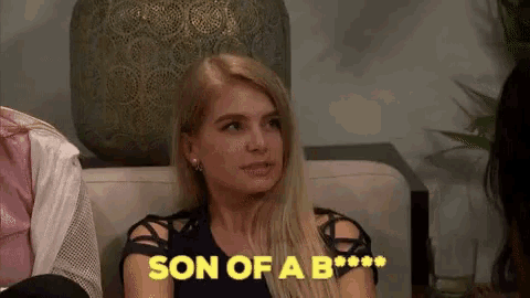a woman is sitting on a couch with the words son of a b written on it .