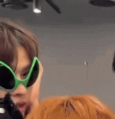 a close up of a person wearing green sunglasses and a pumpkin .