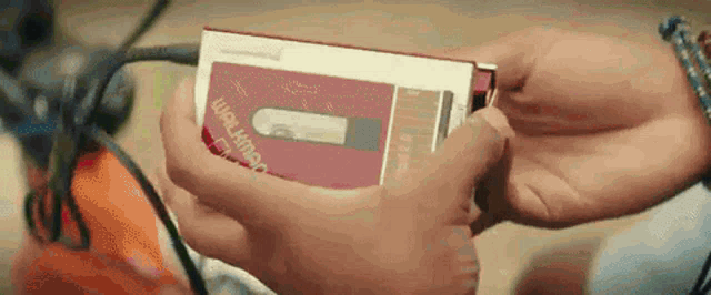 a person is holding a walkman cassette tape in their hands