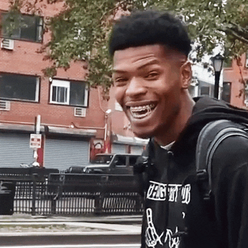 a young man wearing a black shirt that says ' peace out ' on it