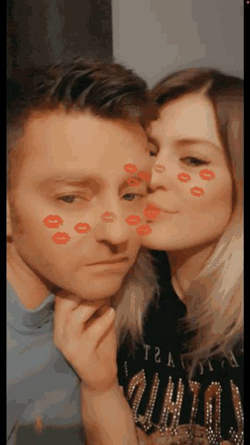 a woman kisses a man on the cheek with red lips on his face