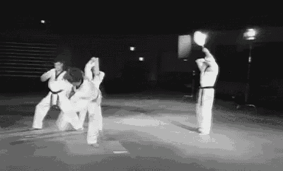 a black and white photo of a group of karate fighters .