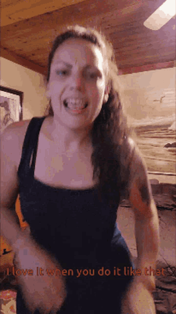 a woman in a black tank top is dancing with the words i love it when you do it like that below her