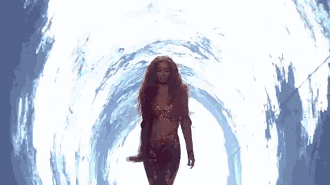 a woman is walking through a tunnel with a microphone .