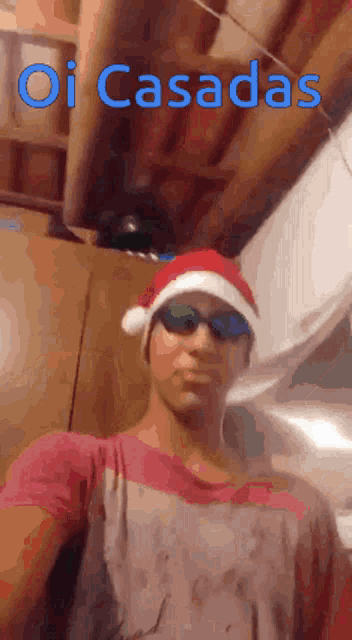 a man wearing a santa hat and sunglasses is taking a selfie with the words oi casadas above him