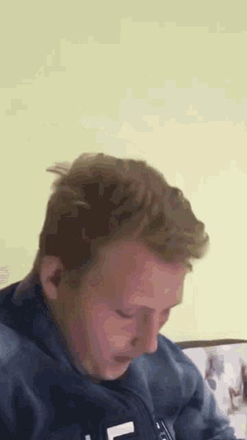 a man in a blue jacket with the letter l on the front