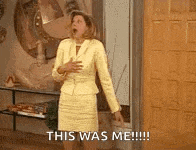 a woman in a yellow suit and hat is standing in front of a door and screaming .