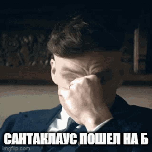 a man in a suit and tie is covering his face with his hand in a meme