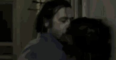 a person is standing in a dark hallway with a shadow on the wall .