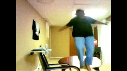 a woman in a black shirt and blue pants is jumping in the air