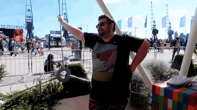 a man wearing a t-shirt with a horse on it is standing in front of a fence