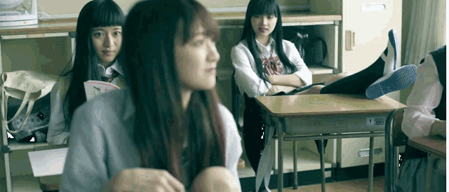 a girl sits at a desk with her feet up and the number 5 on the back of her shirt