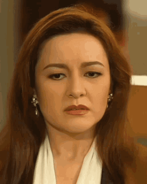 a close up of a woman 's face with a sad look on her face