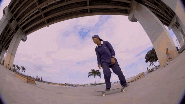 a man riding a skateboard under a bridge
