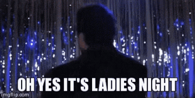 a man in a suit is standing in front of a curtain with the words oh yes it 's ladies night