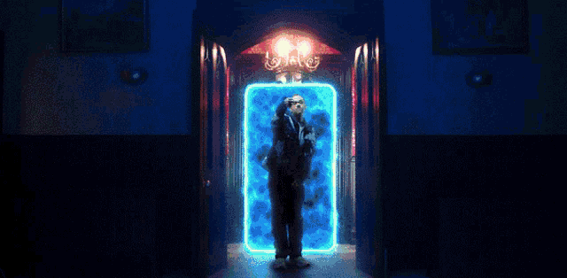 a person is standing in a doorway with a green light behind them